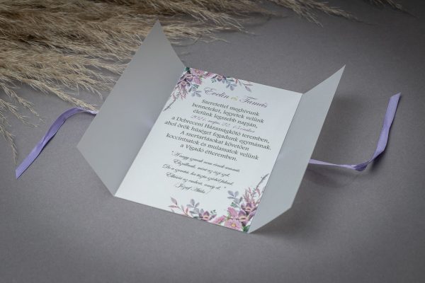 Virágos, pauszpapírral és lila szatén szalaggal díszített esküvői meghívó, mely gyöngyházpapírra van nyomtatva.