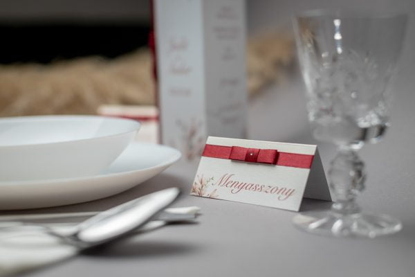 Esküvői ültetőkártya piros szatén szalaggal és strasszkővel